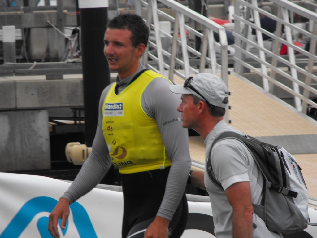 Giles Scott with the yellow jersey with the British Finn coach Stephen Parke after coming in off the water today as the 2011 Finn World Champion - Perth 2011 - ISAF Sailing World Championships © John Curtis